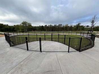 A black metal fence surrounds a concrete area.